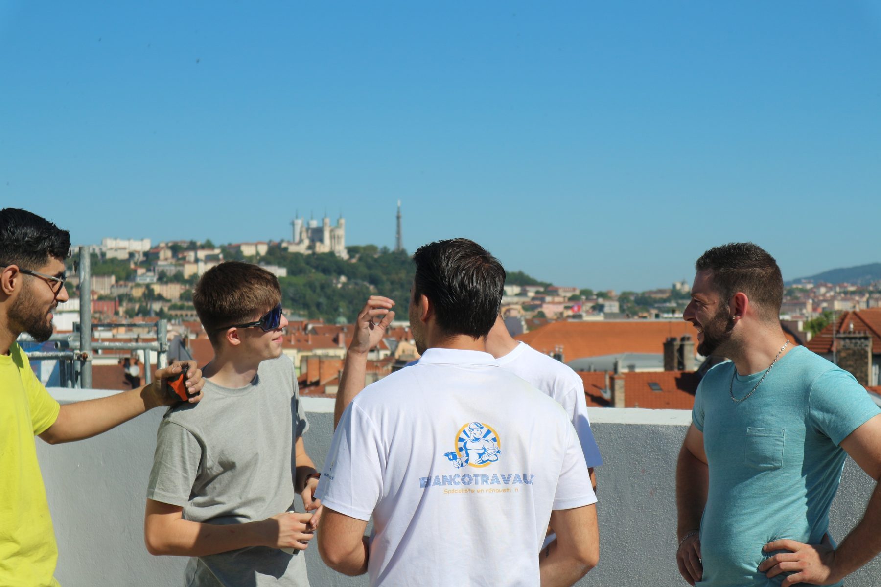L'équipe en discussion sur un toit, la basilique de Fourvière en arrière-plan