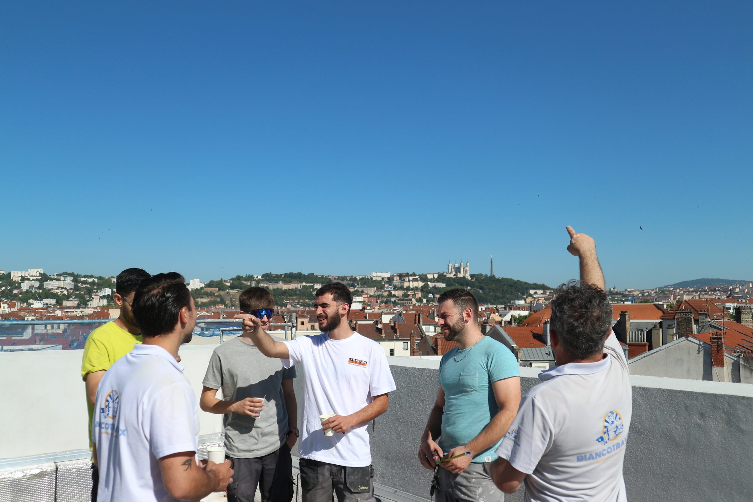 L'équipe Bianco Travaux Énergie réunie sur un toit de Lyon, Fourvière en arrière-plan